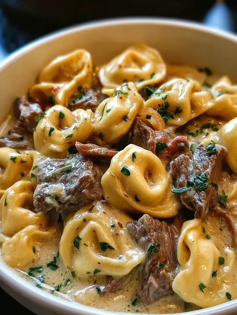 Eine Schüssel Käsesteak-Tortellini in cremiger Provolone-Soße.