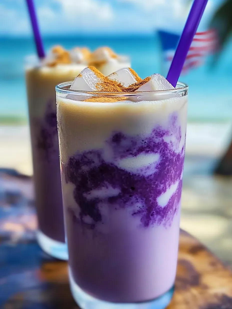 Ein Glas mit lila Getränk, Eis und einem Strohhalm.