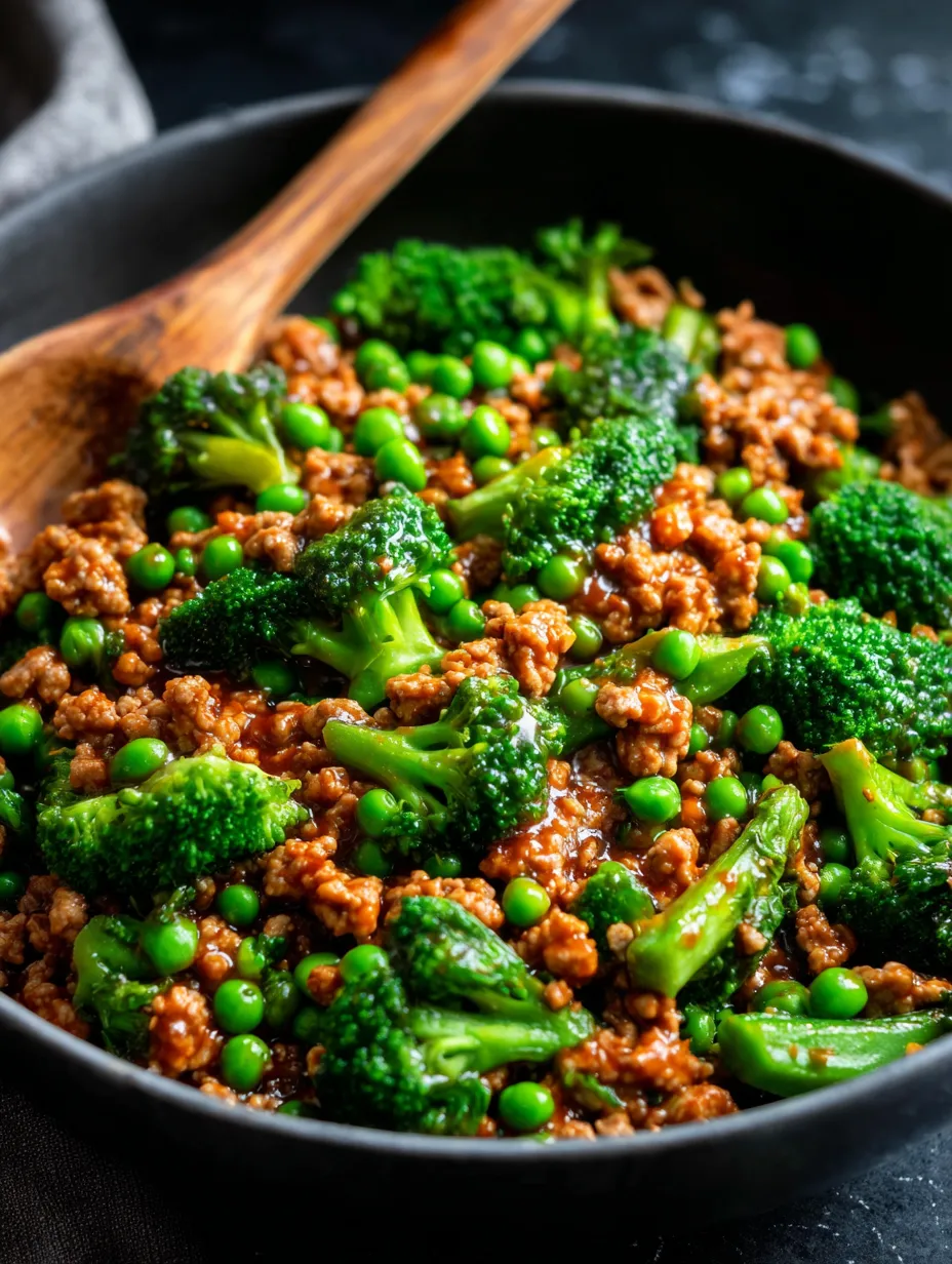 Ein schönes Bild von einer Schüssel mit einer Mischung aus Rindfleisch, Peas, Broccoli und Sauce.