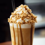 Ein Glas mit Karamellsauce und Sahnehäubchen.