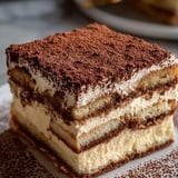 Ein Stück Kuchen mit Schokolade und heller Creme.