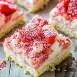 Ein Stück Kuchen mit weißem Frosting und frischen Erdbeeren.