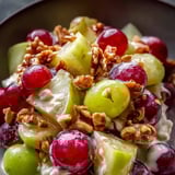 Eine Schüssel voller Obst – mit Trauben, Äpfeln und Walnüssen.