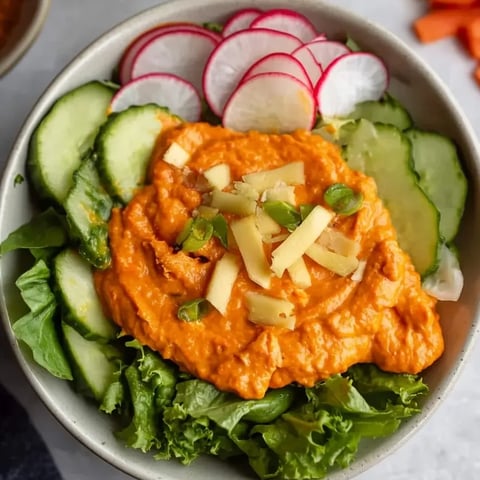 Eine Schüssel Salat mit Gurken, Radieschen und Karotten.