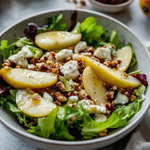 Eine Schüssel Salat mit Birne, Feta und Blattsalat.