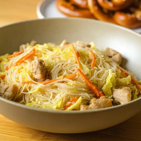 Eine Schüssel Pancit mit Fleisch und Gemüse.